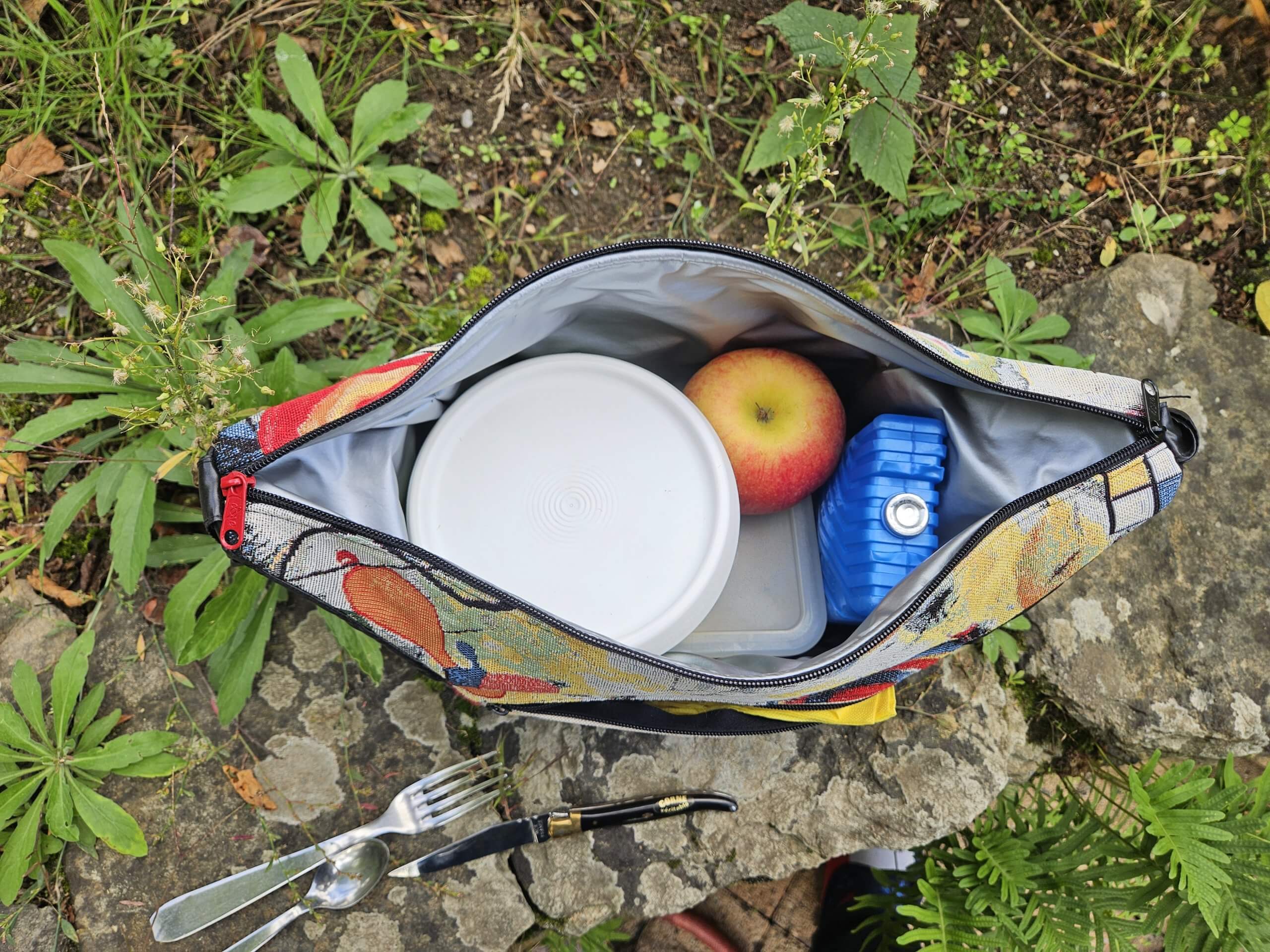 Lunchbox isotherme avec 2 poches latérales extérieures réalisées en tissu déperlant tout comme la principale qui est en plus isotherme.