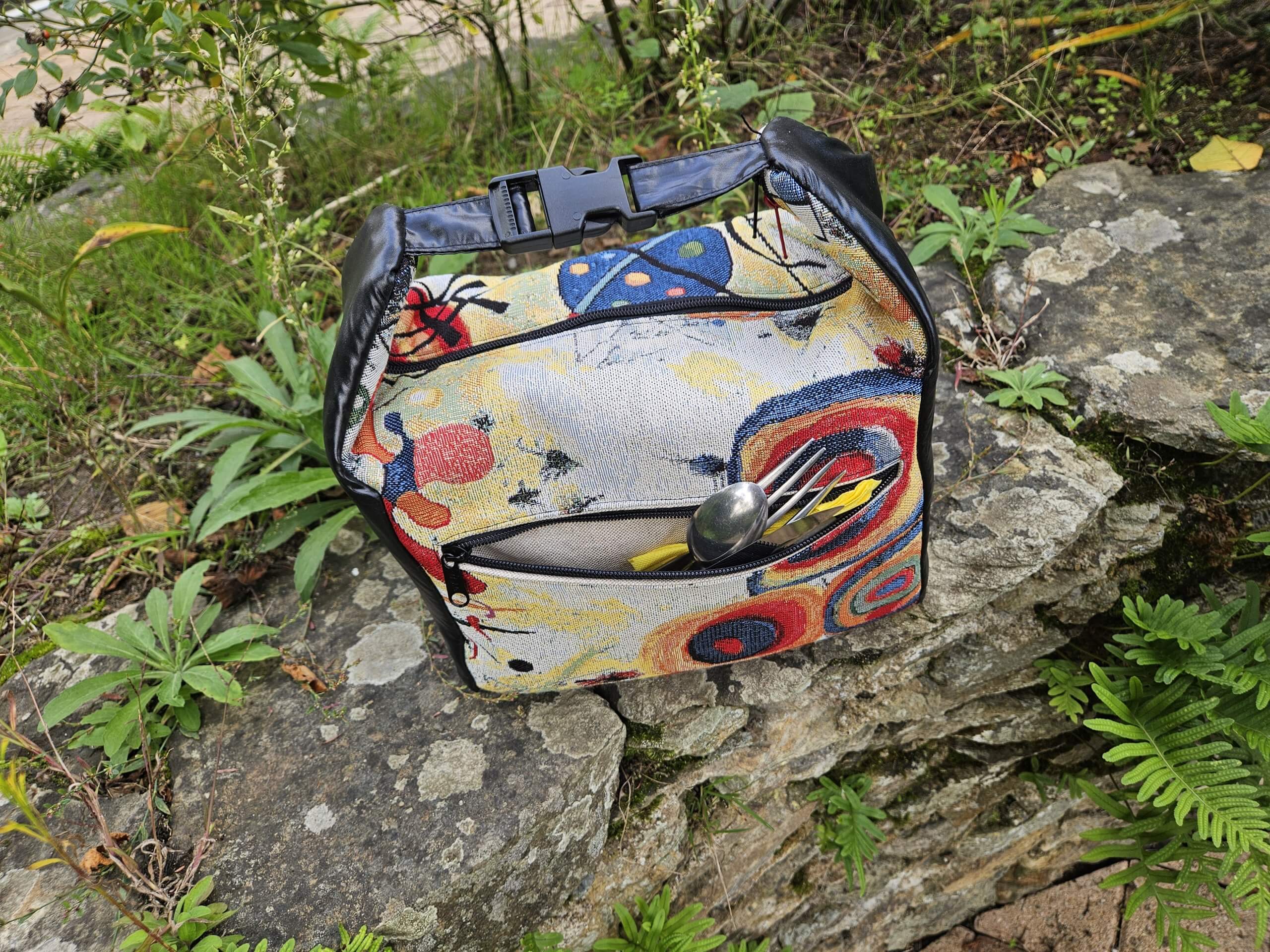 Lunchbox isotherme avec 2 poches latérales extérieures réalisées en tissu déperlant tout comme la principale qui est en plus isotherme.